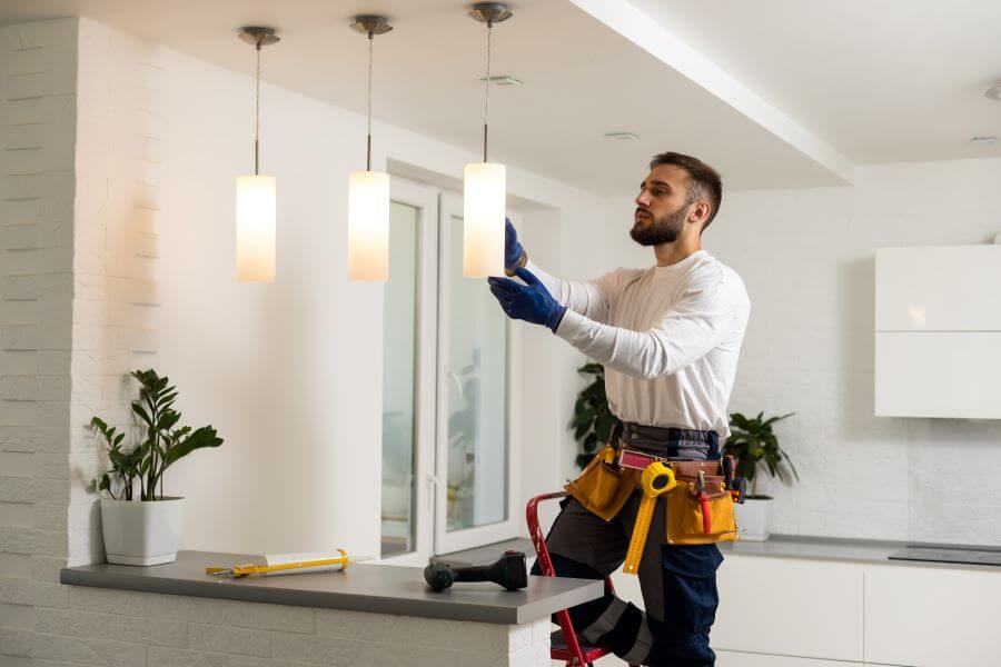 Becoming A Self-Employed Electrician In London: What You Should Know 2 electrician changes lightbulb