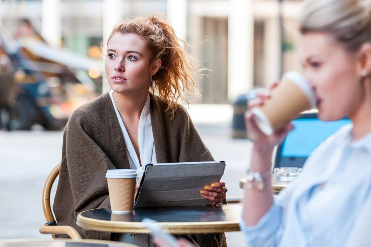 Solo in the City: A Business Traveller’s Guide to London’s Hidden Gems 6 solo female traveller sits at coffee table